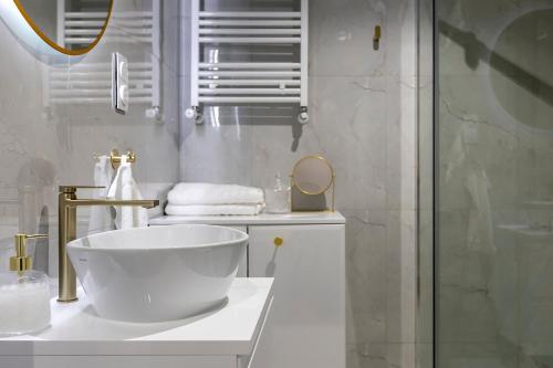 a white bathroom with a sink and a shower at Fabryczna 19 by Farkas Apartments in Poznań