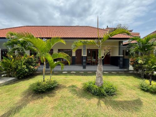 een huis met twee palmbomen ervoor bij Dega Gardens in Canggu