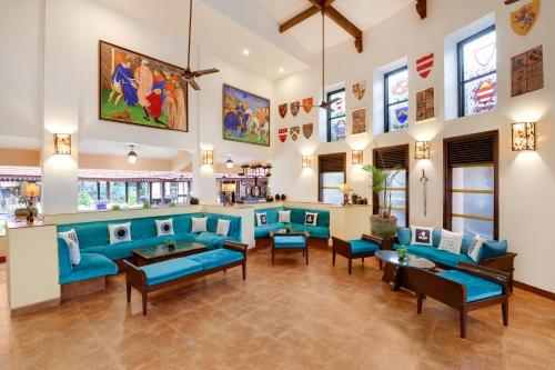 a living room with blue furniture and stained glass windows at Lemon Tree Amarante Beach Resort, Goa in Candolim