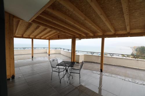 Un balcón con mesa y sillas y vista al mar. en Hotel 1 Maji, en Pogradec