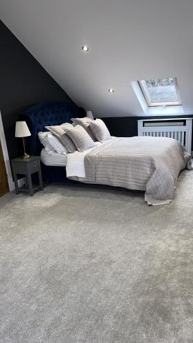 um quarto com uma cama grande e uma janela em Modern Harrogate house sleeps 10, cinema room & hot tub em Harrogate
