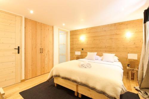 - une chambre avec un grand lit blanc et des murs en bois dans l'établissement Appt Bechar Le Petit Bechar Newly Renovated, aux Houches
