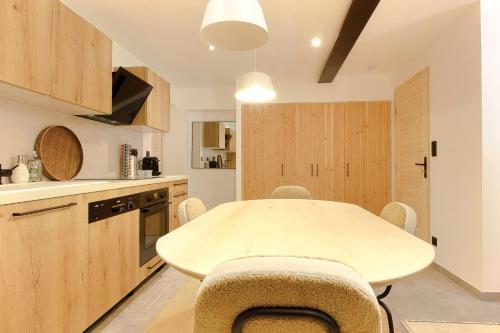 une cuisine avec une table et des chaises dans une pièce dans l'établissement Appt Bechar Le Petit Bechar Newly Renovated, aux Houches