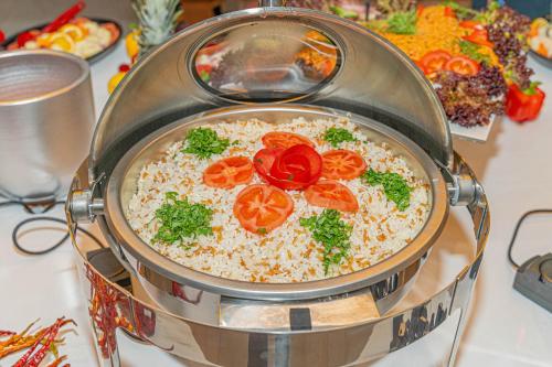 a pot of rice with tomatoes and parsley on a table at Far Life Hotel in Antalya
