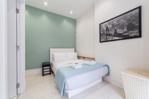 um quarto com uma cama e uma televisão na parede em Charming 1 BR flat near Hyde Park em Londres