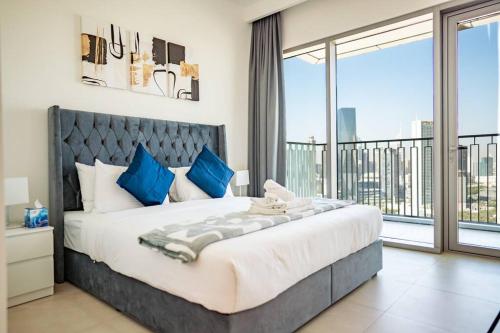 Downtown Views 2BR Luxury Apartment Pool and City Skyline في دبي: غرفة نوم بسرير كبير ونافذة كبيرة
