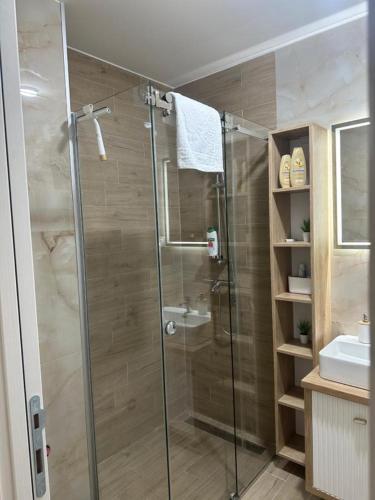 a bathroom with a glass shower and a sink at Ušće in Valjevo