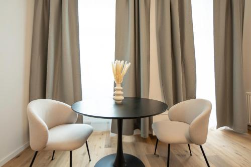 a table with two chairs and a vase on it at Modern apartment with a balcony near Belvedere in Vienna