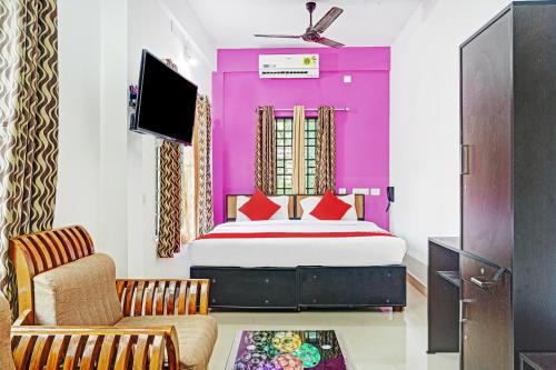 1 dormitorio con 1 cama, TV y sofá en OYO Flagship Thaza en Nedumbassery
