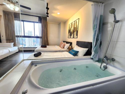 a large bath tub in a room with a bed at Loft Suite City View JB CIQ 7Pax in Johor Bahru