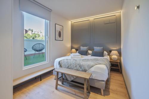 um quarto com uma cama e uma grande janela em Luderna - Arc de Sant Marti Barcelona em Barcelona