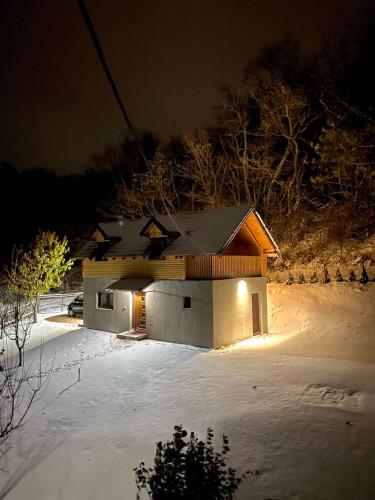 a house in the snow at night at Vikend kuca pod lipom in Rudnik Kačerski