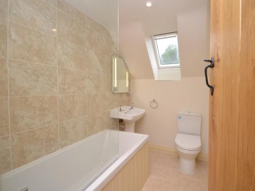 a bathroom with a tub and a toilet and a sink at 2 Bed in Bristol 72582 in Winford