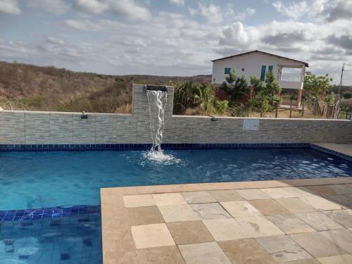 a swimming pool with a water fountain at CHACÁRA SOL NASCENTE in Lavras da Mangabeira
