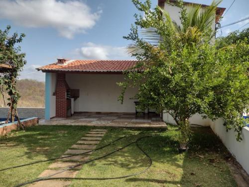 una pequeña casa con un jardín frente a ella en CHACÁRA SOL NASCENTE, en Lavras da Mangabeira