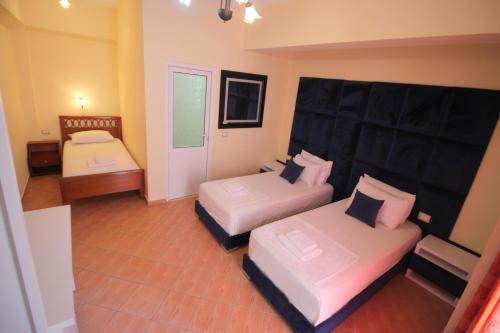 a large room with two beds and a couch at Oskar Hotel in Sarandë