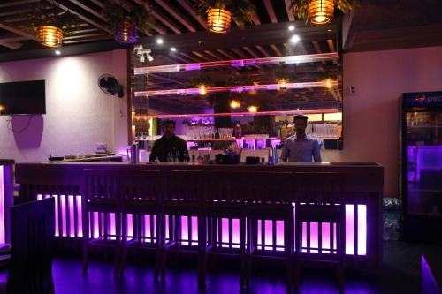 bar w restauracji z fioletowymi światłami w obiekcie Hotel Royal w mieście Rājpura