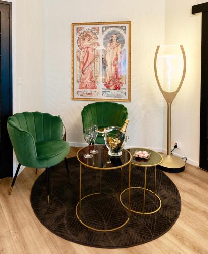 - un salon avec deux chaises vertes et une table dans l'établissement Résidence Champenoise Lancelot Rouyer ST RÉMY, à Épernay