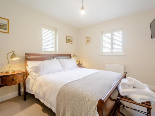 a bedroom with a bed and two windows at 1 bed property in Tetbury 79151 in Tetbury