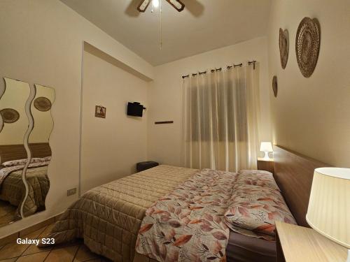 a small bedroom with a bed and a window at La Casita Il Poggio Del Sole in Letojanni