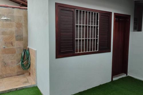 um quarto com uma porta, uma janela e relva verde em excelente casa ótima localização em Ubatuba
