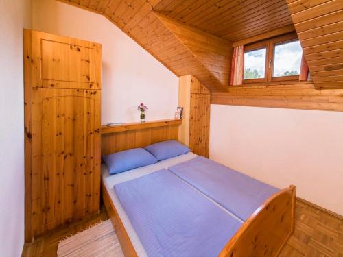 ein Schlafzimmer mit einem Bett in einer Holzhütte in der Unterkunft Ilsenhof am Turnersee in Obersammelsdorf