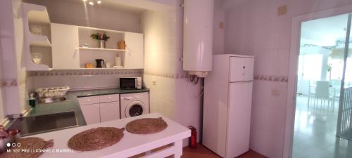 een keuken met een witte koelkast en een wasmachine bij Big and cozy apartment with a big terrace in the center of the old town with AC from 2024 summer season in Marbella