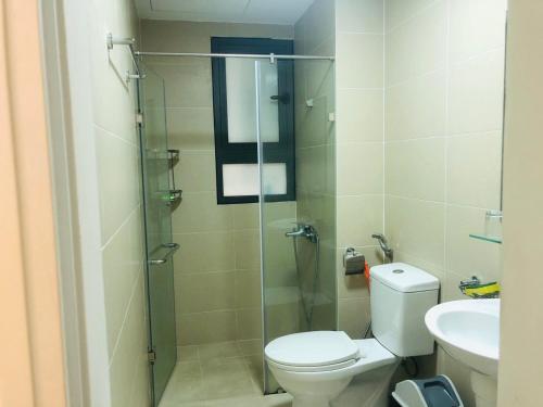 a bathroom with a toilet and a glass shower at CĂN HỘ CAO CẤP CÓ HỒ BƠI TẠI BIÊN HÒA in Bien Hoa