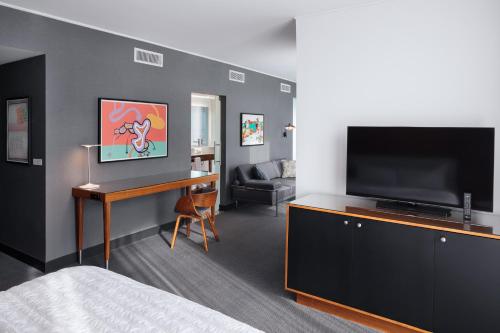 a bedroom with a bed and a flat screen tv at Le Méridien Columbus, The Joseph in Columbus