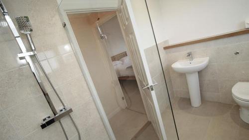 a bathroom with a shower and a toilet and a sink at Seacliffs in Rhossili