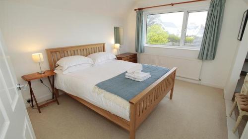 a bedroom with a large bed and a window at Seacliffs in Rhossili