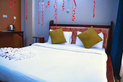 a bedroom with a bed with christmas decorations on the wall at GOLDEN QUEST HOTEL in Entebbe