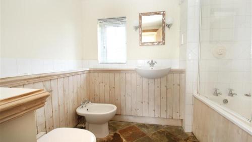 La salle de bains est pourvue de toilettes et d'un lavabo. dans l'établissement Middleton Hall Cottage, à Rhossili