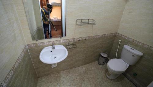 a bathroom with a sink and a toilet and a mirror at Anh Tuấn Motel in Hue