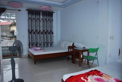 a bedroom with a bed and a desk and a table at Anh Tuấn Motel in Hue