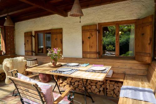 uma mesa de madeira e cadeiras num pátio em Speckbacher Hof - Historisches Bauernhaus im Chiemgau em Unterwössen