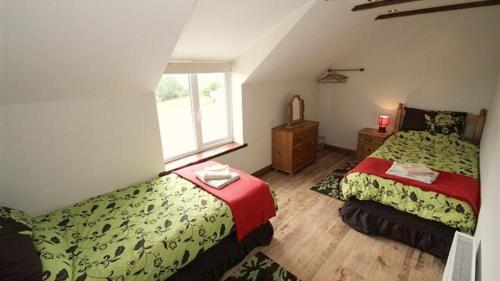 a bedroom with two beds and a window at Llanelen Farm Sleeps 2 in Llanrhidian