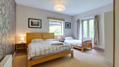 a bedroom with two beds and a window at Ship Cottage in Bishopston