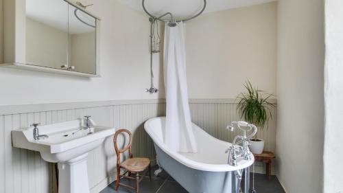 ein Badezimmer mit einem Waschbecken und einer Badewanne in der Unterkunft Ship Cottage in Bishopston
