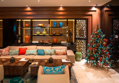 a christmas tree in a living room with a couch at Mala Garden Design Hotel in Siófok