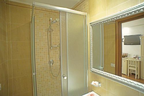 a bathroom with a shower with a mirror and a sink at Locanda Navona in Rome