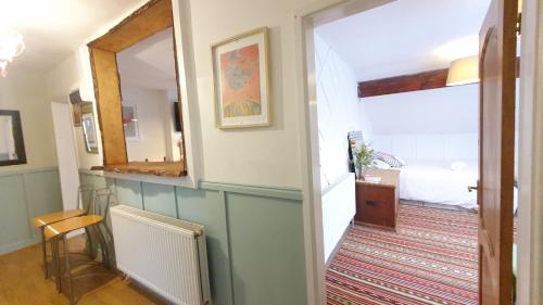 einen Flur mit einem Zimmer mit einem Bett und einem Spiegel in der Unterkunft The Loft at York House in Birmingham