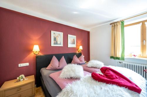 a bedroom with a bed with red walls at Ferienwohnung Alpensonne in Oberstdorf