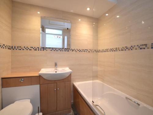 a bathroom with a sink and a toilet and a bath tub at 2 Bed in Widemouth Bay 55833 in Marhamchurch
