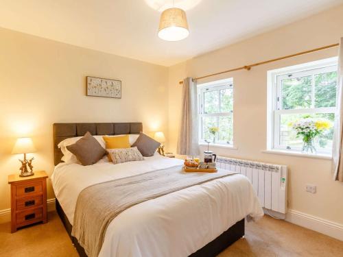a bedroom with a large bed and two windows at 1 Bed in Pateley Bridge 89152 in Summer Bridge