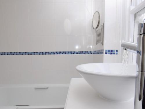 a white bathroom with a tub and a sink at 2 Bed in Appledore SALSP in Appledore