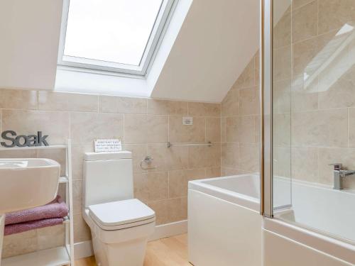 a bathroom with a toilet and a tub and a sink at 3 Bed in Looe 51029 in Saint Cleer