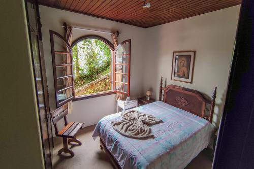een slaapkamer met een bed en een raam bij Casa com lareira e Wi Fi em Campos do Jordao SP in Campos do Jordão