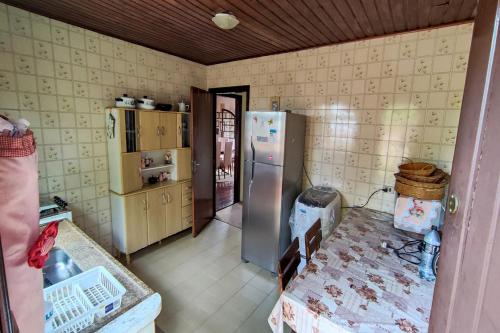 een keuken met een roestvrijstalen koelkast in een kamer bij Casa com lareira e Wi Fi em Campos do Jordao SP in Campos do Jordão
