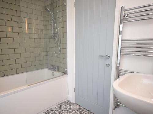 a white bathroom with a tub and a sink at 4 Bed in Appledore 55573 in Appledore